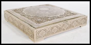 A Persian Islamic silver white metal square trinket box with large central medallion with
