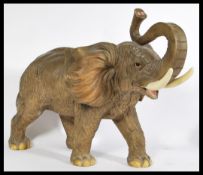 A large composite constructed sculpture of an African Bull Elephant with trunk raised in salute.