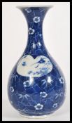 An early 20th century Chinese baluster hand painted blue and white vase having white cartouche