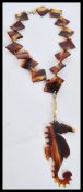 A vintage tortoise shell necklace having a seahorse design pendant, a round spring clasp and
