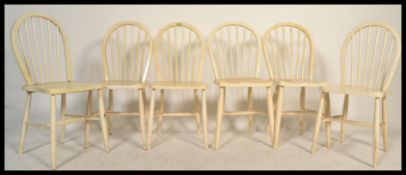 A set of six white painted Ercol style spindle back Windsor chairs raised on tapered legs.