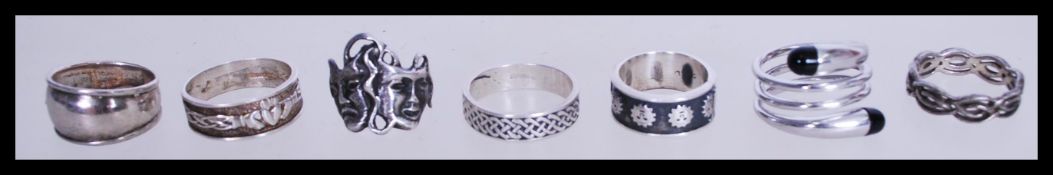 A collection of seven silver rings to include a 925 silver claddagh ring, a celtic knot decorated