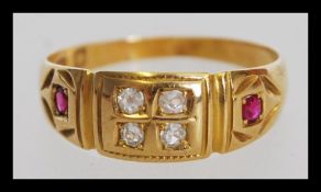 A 19th century Victorian 18ct gold ring with four inset white stones and two red stones. The ring is