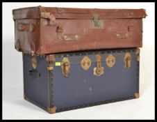 A vintage retro 20th century blue steamer trunk along with an early leather trunk. Please see