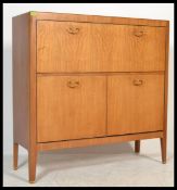 A vintage retro teak wood Danish inspired highboard / sideboard, having an arrangement of