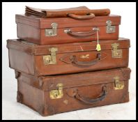 A good collection of vintage 20th century leather luggage to include four suitcases and a briefcase.