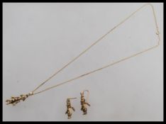 A set of 9ct gold articulated clown earrings and necklace having inset rubies, emeralds and