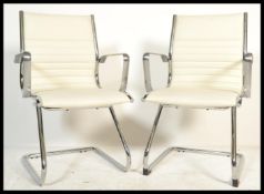 A pair of Charles and Ray Eames inspired cantilever executive / dining chairs having the ribbed