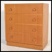 A vintage retro 20th century oak straight four chest of drawers. The bank of drawers raised on a