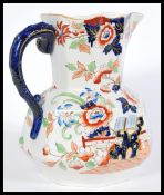 A 19th century large Masons jug having a chinoiserie pattern featuring peony flowers, shaping to the