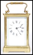 A 20th century brass carriage clock with exposed internal mechanisms, with a white face and roman