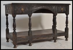 A Jacobean 19th century revival hall  console lowboy table, heavily carved throughout, arched frieze
