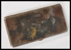A vintage 20th century cigarette case with oriental engraving to the front depicting a mountain