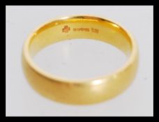 A 22ct gold band wedding ring weighing 8.2g. The ring is hallmarked millennium 1999-2000, 916 and is
