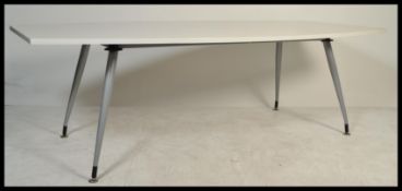 A large contemporary white high gloss executive conference / dining table raised on round tapering