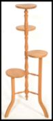 A 20th Century four tier pine plant stand / torchere, central turned column raised on tripod splayed
