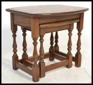 A 20th Century Old Charm oak nest of tables, each table raised on turned supports united by