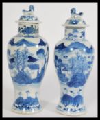 A pair of 19th century Chinese lidded urn vases having hand painted blue and white decoration with