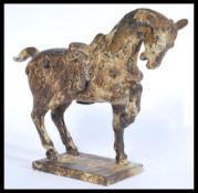 A Chinese Tang Dynasty style bronze figurine of a warhorse. The horse raised on square base with