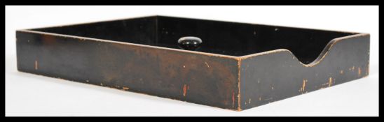 A vintage 1920's black lacquered desk in tray with a fitted cover and turned knob handle.