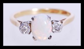 An 18ct gold opal and white stone ring having a central opal panel flanked by two illusion set white