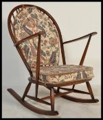 A mid 20th century Ercol beech and elm wood whelback windsor pattern rocking chair - armchair being
