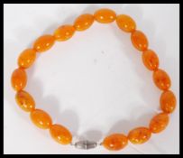 A vintage butterscotch amber or amber type bead necklace having 17 amber beads with silver white