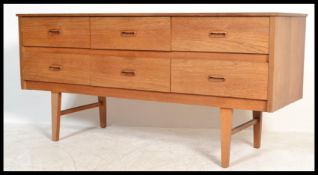 A retro 20th Century teak wood Danish inspired six drawer sideboard, having an arrangement of six