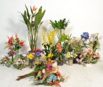 A large collection of artificial flowers and plants set in pots and vases to include rubber