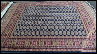 A large  vintage Persian floor carpet Bokhara rug having a blue ground with geometric borders and