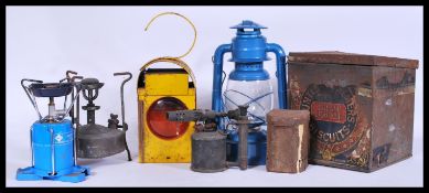 A group of vintage retro oil lamps and work lamps to include yellow enamel work lamp with red glass,