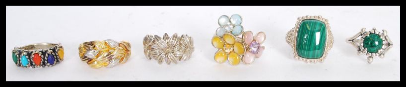 A collection of 20th century silver rings to include a gold plated floral decoration ring, two