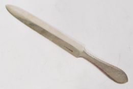 A silver hallmarked letter opener of larger form having shaped handle with engraved design. Weighs