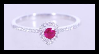 A 20th century 18ct white gold ring with pear shaped red stone surrounded with diamonds and having