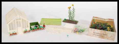 A group of vintage Britains garden items to include various flowers and bases along with a