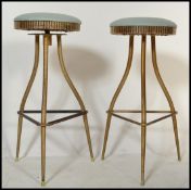 A pair of vintage 20th century brass tubular machinist stools raised on tubular tripod supports with