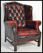A 20th century Antique style oxblood leather chesterfield armchair being raised on cabriole legs