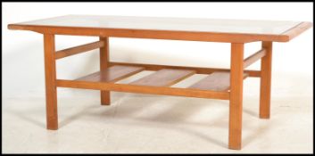 A 1970's retro teak and smoked glass coffee - occasional table being raised on squared legs with