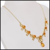 A stamped 375 9ct gold necklace with citrine stones and pearls set in a decorative floral design.