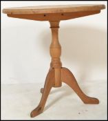 A Victorian style country pine tripod dining table raised on turned column base with tilt top