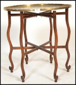 A 20th century Chinese brass charger occasional table. The brass tray of circular form having