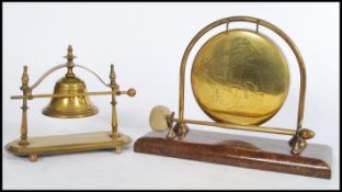 An early 20th century oak table top gong and striker. The large brass gong with oak setting, the