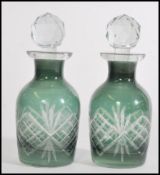 A pair of two small Victorian green cut glass perfume bottles with a cut glass finial stoppers.
