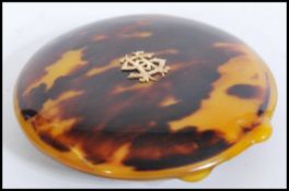 A vintage 20th century faux tortoiseshell compact of circular form having gold monogram to lid.