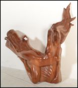 A 20th century teak wood carved statue of a posed nude female, with a polished finish.