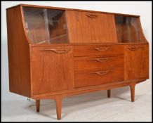 A 1970's retro G-Plan teak wood highboard sideboard raised on turned legs with cabinets and