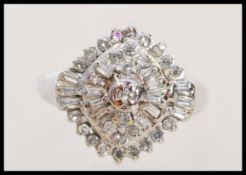 A stamped 10ct white gold and diamond cluster Art Deco style ring with inset square baguette and