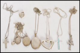 A group of sterling silver necklaces to include oval form lockets, crucifix pendants and heart
