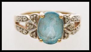 A hallmarked 9ct gold diamond and blue stone ring with a large central oval cut blue stone in a