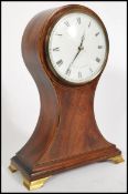 A Comitti of London balloon shaped mahogany clock, Roman numeral chapter dial raised on brass